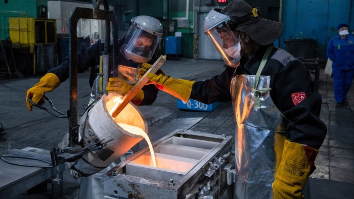 Workers pour molten silver into molds