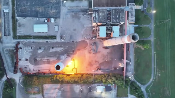 Moment power station chimneys crumble to ground in blast