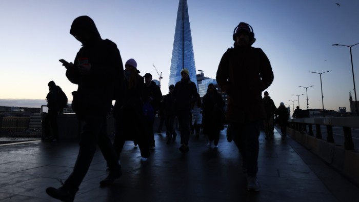Commuters walk over London Bridge