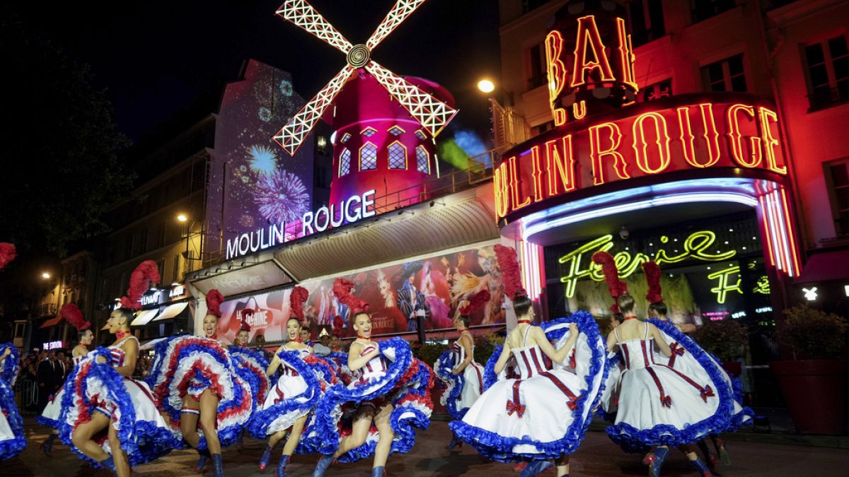 الاحتفالات Can-Can بينما تتحول طواحين طواحين مميزة Moulin Rouge مرة أخرى