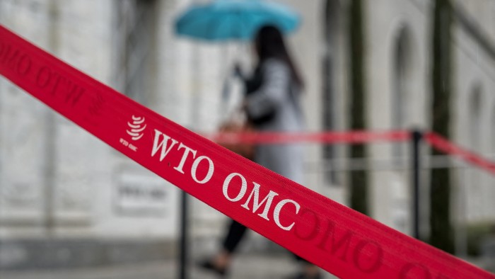 A woman enters the World Trade Organization headquarters in Geneva