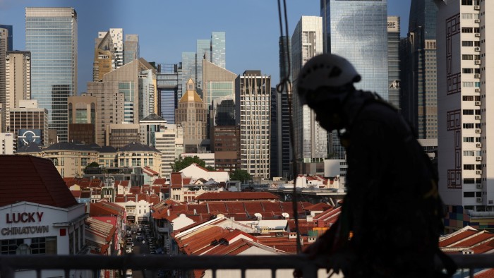 A worker climbs over a railing in Singapore