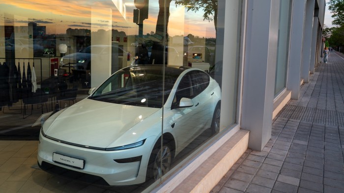 A Tesla Model Y electric vehicle in the window of a dealership in Valencia, Spain