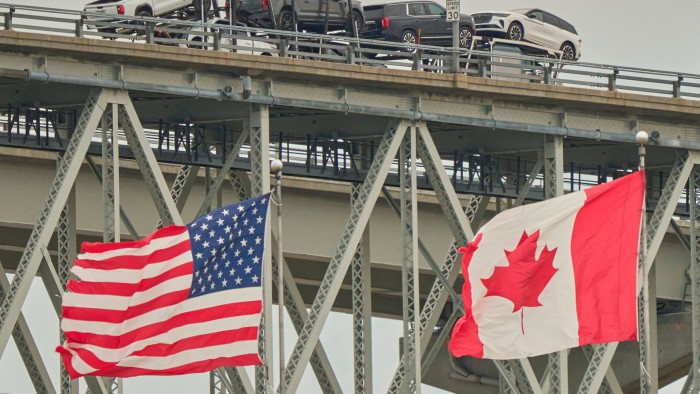 A truck carrying vehicles crosses the Blue Water Bridge border crossing into the United States from Sarnia, Ontario