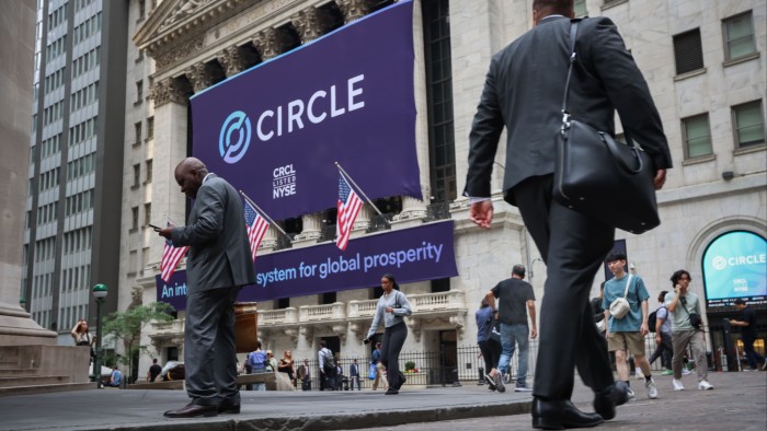 People walk outside the New York Stock Exchange with the Circle’s sign on the building