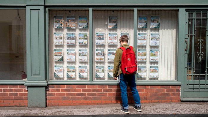 A person looks through the window of an estate agent in Birmingham