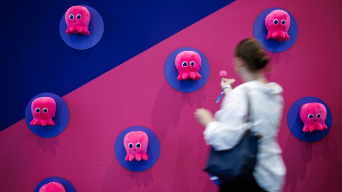 A visitor passes soft octopus toys at Octopus Energy’s booth at a trade fair in Berlin, Germany in September 2024
