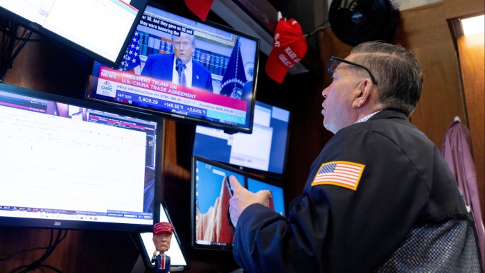 US President Donald Trump is seen on a television screen while a trader works on the floor of the New York Stock Exchange