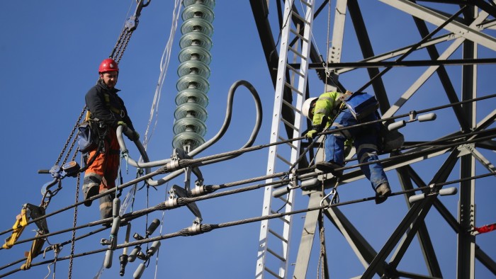 Technicians perform maintenance tasks on an electricty pylon