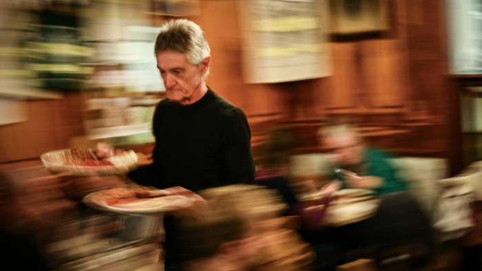 A waiter delivers food in a restaurant