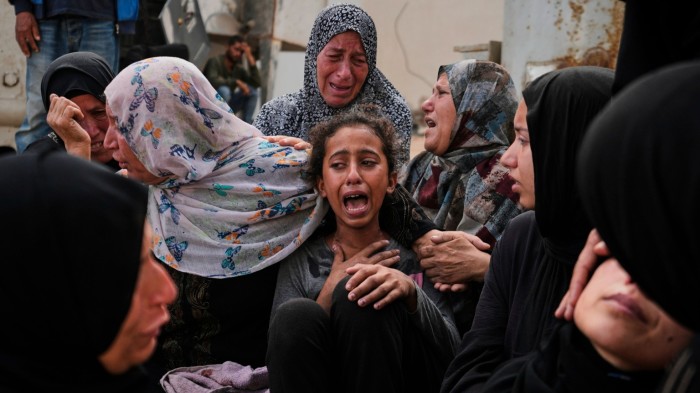 Lian Al-Za’anin is comforted by relatives as she mourns the loss of her father